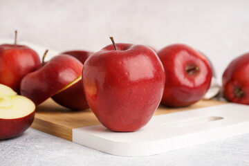Board with fresh red apples on white background