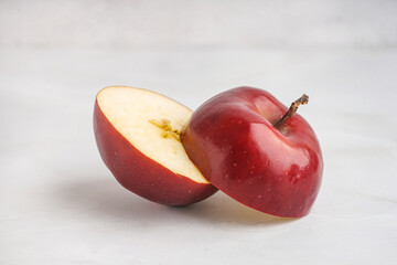 Halves of fresh red apple on white background