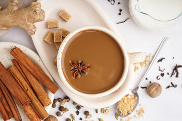 Cup of tasty masala tea with different spices on light background, closeup