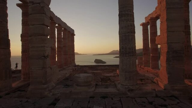 epic drone footage of Poseidon Temple at golden hour sunset , touristic area