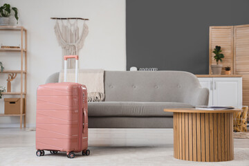 Pink suitcase in living room interior