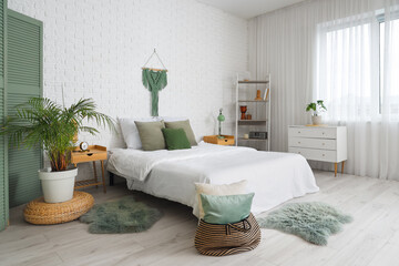 Interior of modern bedroom with soft pillows on cozy bed