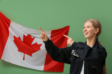 Female police officer pointing at something and flag of Canada on green background