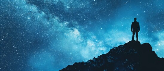 A solitary man standing at the peak of a mountain, staring up at the vast expanse of the night sky filled with twinkling stars and distant galaxies - obrazy, fototapety, plakaty