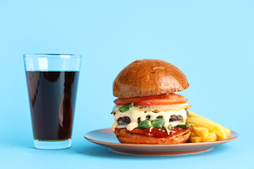 Plate with tasty burger, french fries and glass of cola on blue background