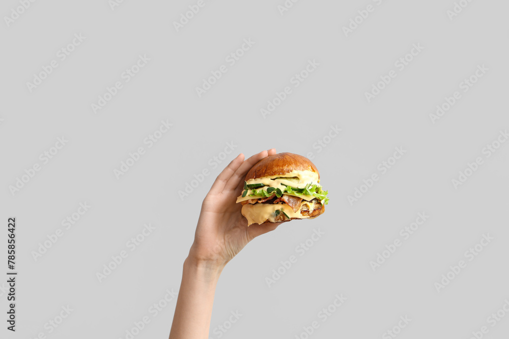 Sticker female hand with tasty burger on white background