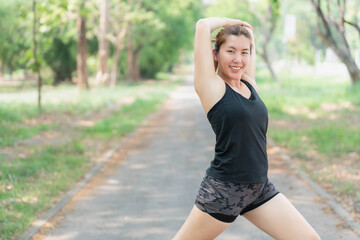 Asian woman stretching before jogging at the park. Health and body care concept. Weight loss, weight loss.