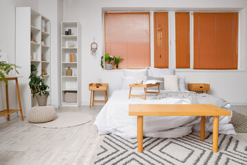 Interior of light bedroom with wind chime, dream catcher and plants