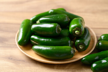 Fresh green Jalapeno chili on wooden plate, Food ingredient
