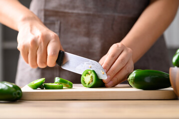 Fresh green Jalapeno chili cutting on wooden board
