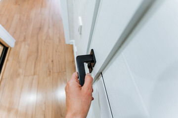 Hand on door handle, opening hardwood door in wooden building