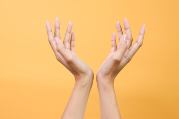 Female hands holding gesture cosmetic product presentation and object display isolated on yellow background