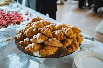 A glass plate of croissants, a delicious baked goods on a tabletop