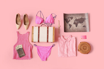 Suitcase with female clothes, map and passport on pink background. Travel concept