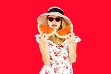 Caucasian woman holding two slices of watermelon