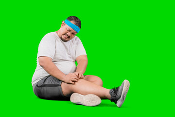 Portrait of young plus size overweight man holding a knee suffering from osteoarthritis