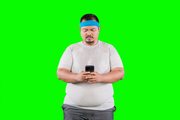 Overweight Asian guy looking at his mobile phone