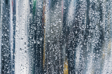 raindrops on glass window in rainy day with blurred street background. - 785887846