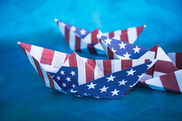 Paper boat with American flag on blue background.  Columbus day concept.