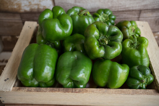 Fresh green bell pepper on wooden background.