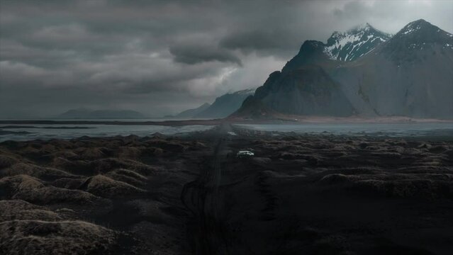 Drone footage over Stokksnes black sand beach, showcasing dramatic clouds and the majestic Vestrahorn mountain, Iceland
