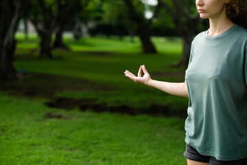 Women's hand folded into mudra during meditation, close-up, practice in the open air.