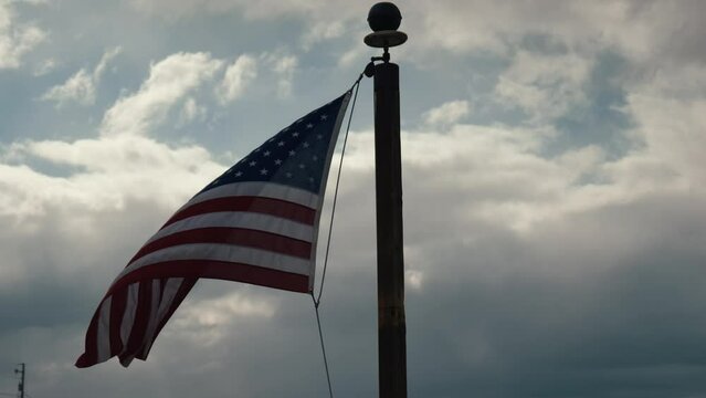 American flag waving in the wind with storm clouds 