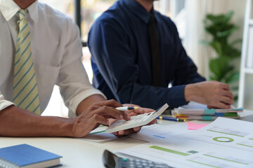 Financial analyst analyzes business finance reports on laptop and graph documents during corporate meeting discussions showing successful teamwork, business meeting ideas, marketing.