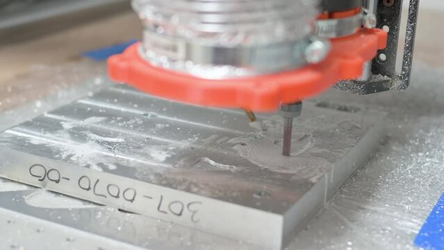 CNC machine engraving a block of aluminum