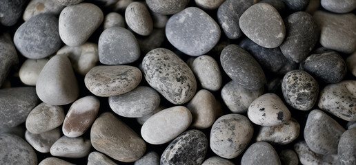 Fototapeta na wymiar smooth, round, medium-sized grey stones with slight variations; background image