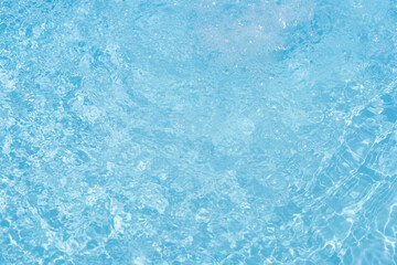 Bluewater waves on the surface ripples blurred. Defocus blurred transparent blue colored clear calm water surface texture with splash and bubbles. Water waves with shining pattern texture background.
