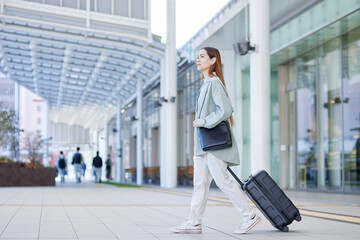 スーツケースを持って移動する女性のインバウンド外国人旅行者
