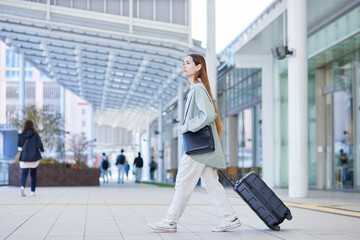 スーツケースを持って移動する女性のインバウンド外国人旅行者