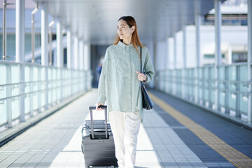 スーツケースを持って移動する女性インバウンド海外旅行者