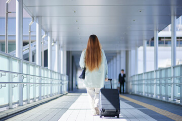 スーツケースを持って移動する女性インバウンド海外旅行者 - obrazy, fototapety, plakaty