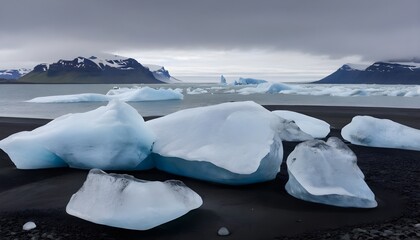 Ice chunks on a black sand beach with waves in the background - obrazy, fototapety, plakaty
