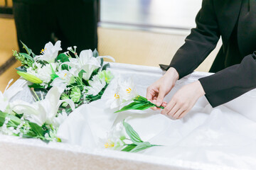 お葬式で泣く喪服を着た遺族の高齢者女性と若い日本人女性
