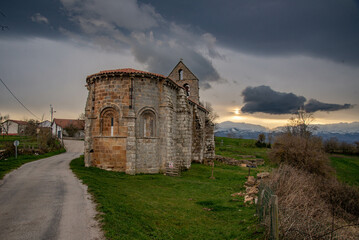 iglesia romanica junto a ruinas romanas en Retortillo Cantabria en una puesta de sol - obrazy, fototapety, plakaty