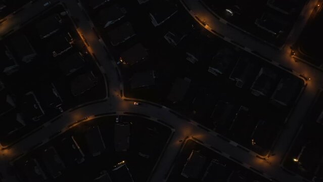 High aerial top down shot above street with lights at night. American neighborhood after dark.