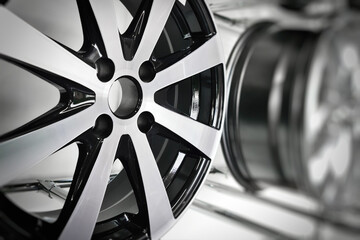 Close-up of light alloy wheels designed for passenger cars on display at a store stand.
