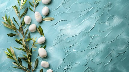 An image capturing an olive branch with white stones on a light turquoise background