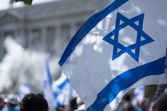 Demonstrators wave Israeli flags in front of San Francisco City Hall.