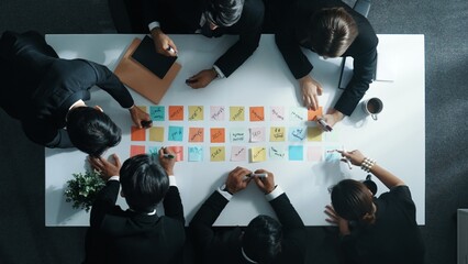 Top down aerial view of manager discuss and choose marketing idea from sticky notes. Group of...