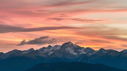 A sunset view over a mountain range with a clear sky and warm, soft colors.