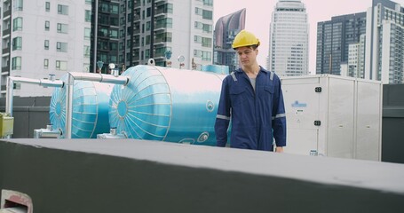 Engineer man in a blue jacket is walking inspecting maintenance insulated pipelines valve pump...