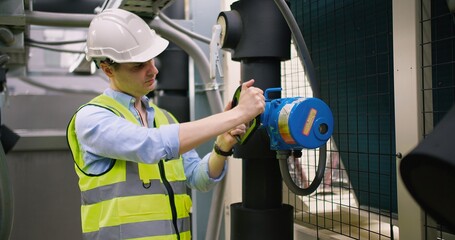 Civil engineer manager checking industry cooling air conditioner water cooling tower air chiller of...