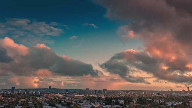 Beautiful storm clouds flying in blue sky over city of Los Angeles cityscape at sunset. Aerial hyperlapse timelapse.