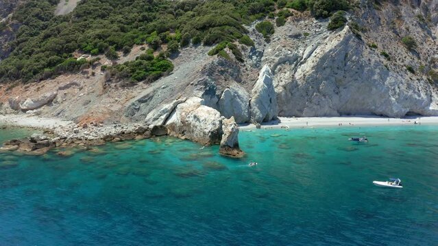 Aerial: Slow orbit shot of the limestone arch rock formation in Lalaria beach in Skiathos island, Sporades, Greece on a sunny day