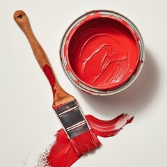 Top view of open red paint can with stir stick and paintbrush with red stroke on white surface.