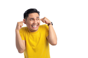 Annoyed young Asian man plugging ears with fingers showing displeased expression isolated on white background